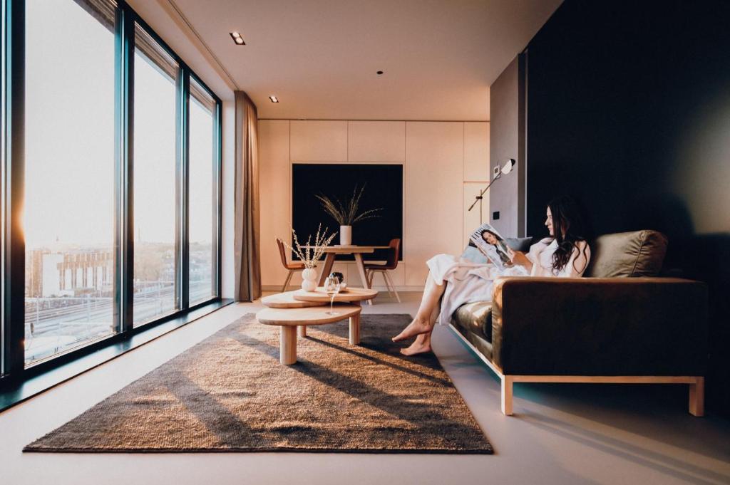 乌得勒支CREATIVE VALLEY NEST – Luxury Rooftop Apartments的坐在客厅沙发上的女人
