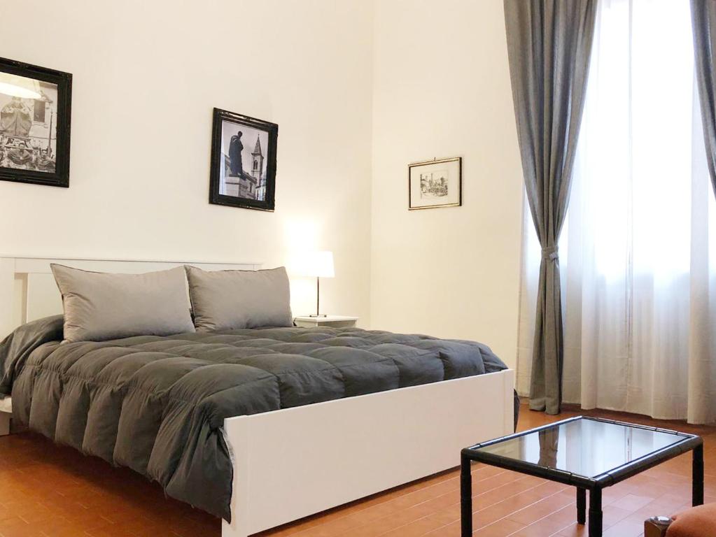 苏尔莫纳Brand New Apartment in Sulmona的一间卧室配有一张床和一张玻璃桌