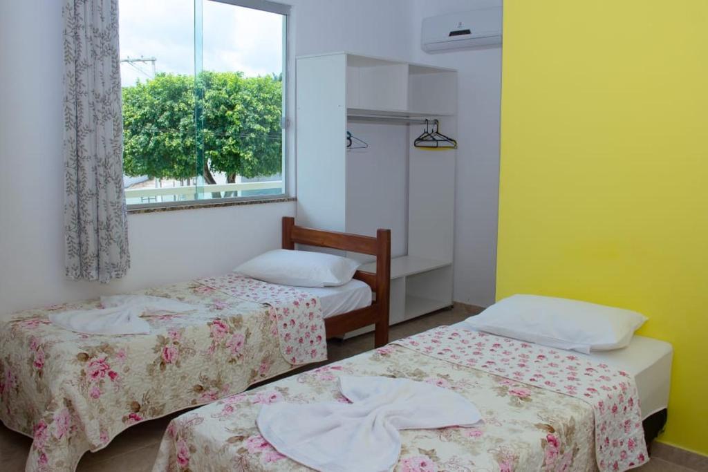 UnaPOUSADA DA ILHA的客房设有两张床和窗户。