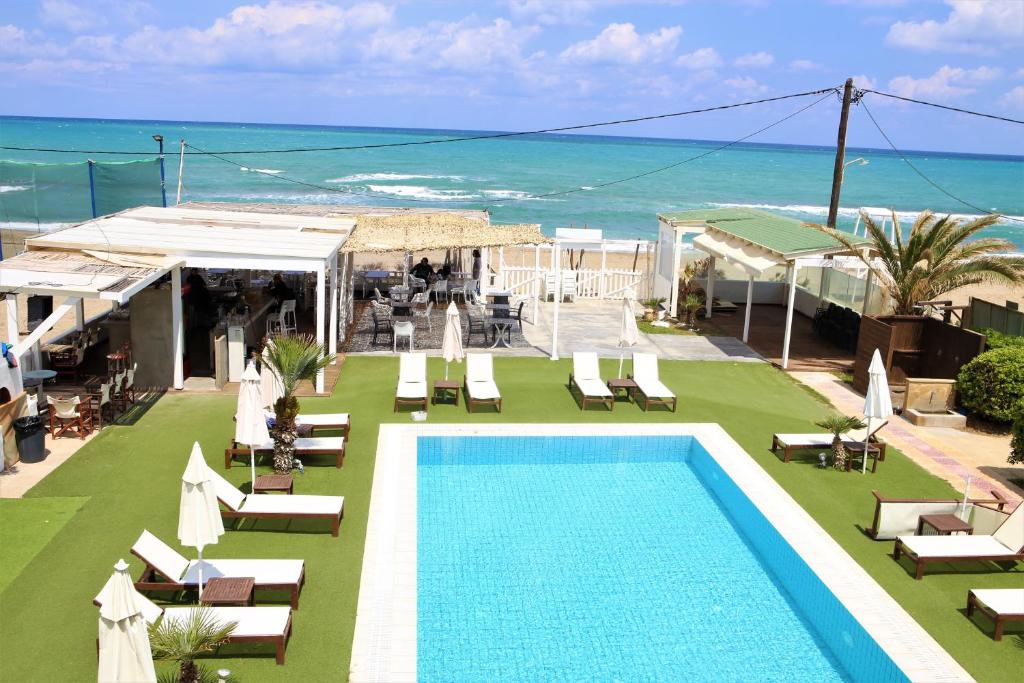 阿默达拉-伊拉克利翁Havana 1 Sea and Pool Apartment的一个带游泳池和椅子的度假胜地和大海