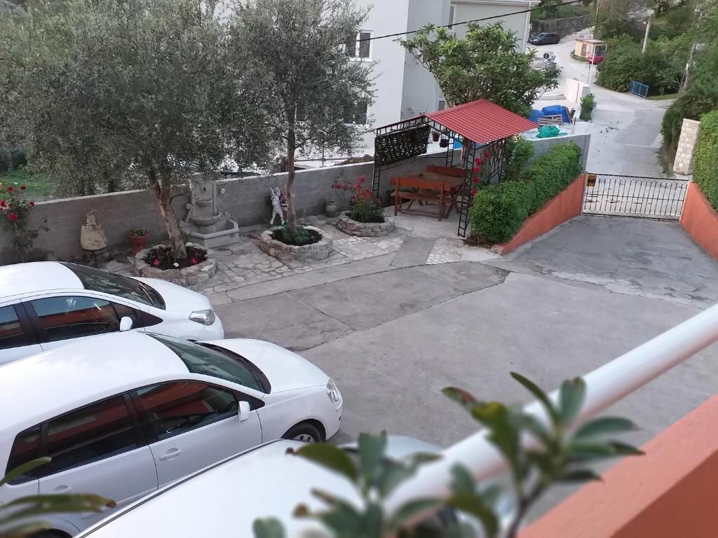蒂瓦特Apartment Matkovic的两辆白色汽车停在停车场,配有桌子