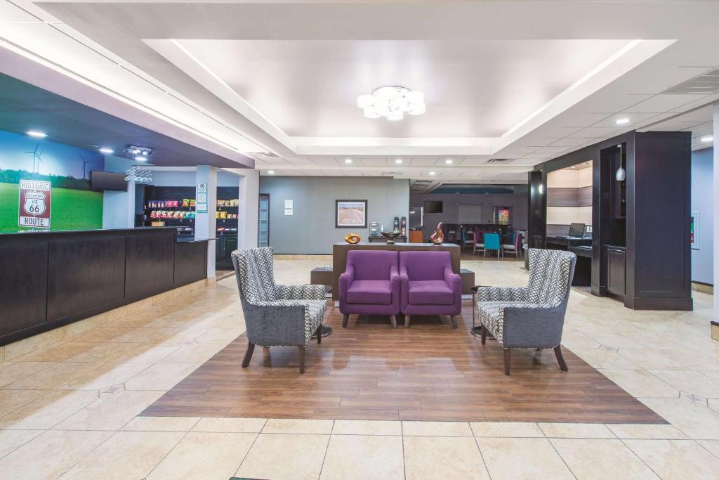 塔尔萨塔尔萨机场/博览广场拉金塔旅馆&套房酒店的大堂设有紫色椅子和等候区