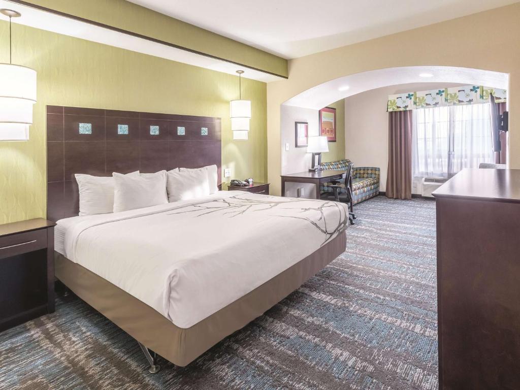 大草原城拉金塔达拉斯大草原城套房酒店的酒店客房设有一张大床和一张书桌。