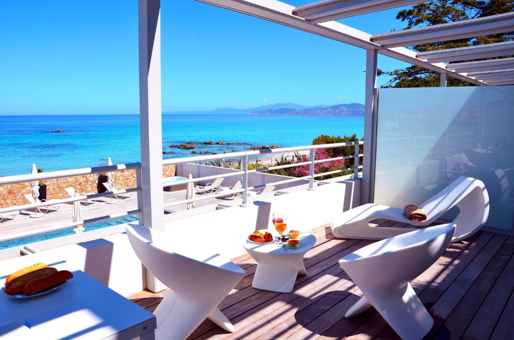 利勒鲁斯凯里公寓酒店的阳台配有白色椅子,享有海景。