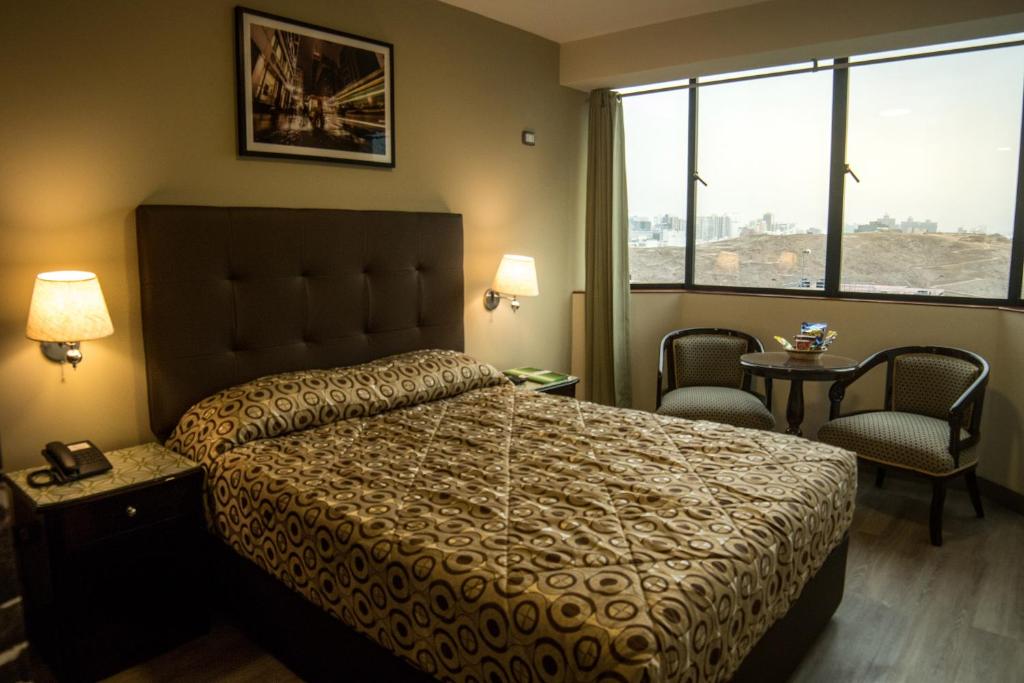 利马雷克萨斯酒店的一间卧室配有一张床、两把椅子和一个窗户