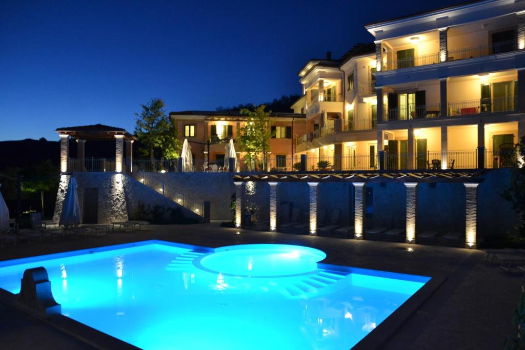 托尔托雷托因坎提度假酒店的一座游泳池,在晚上在建筑物前