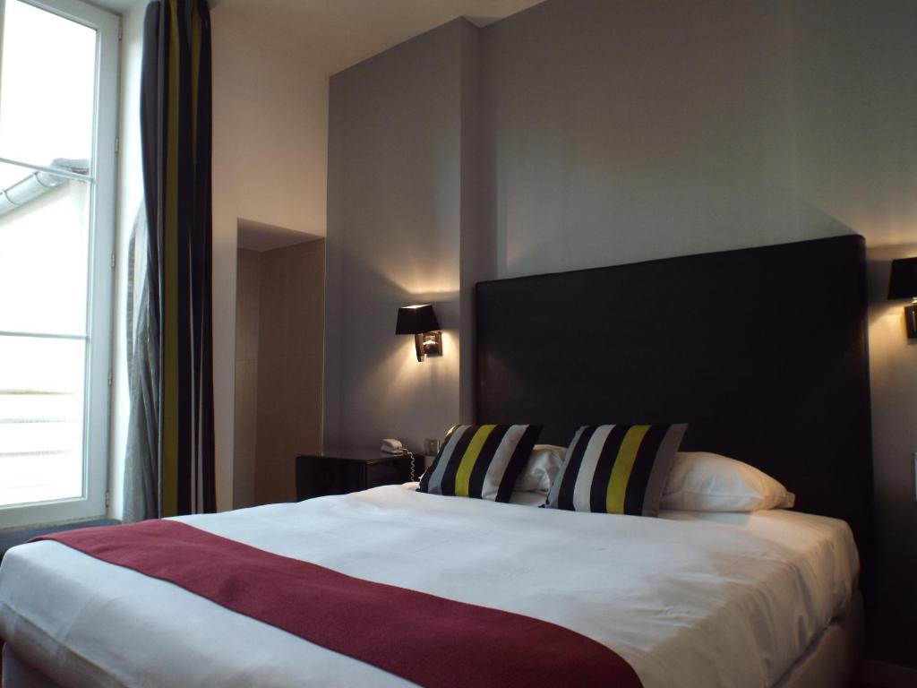 奥尔良圣马丁酒店的一间卧室设有一张大床和大窗户