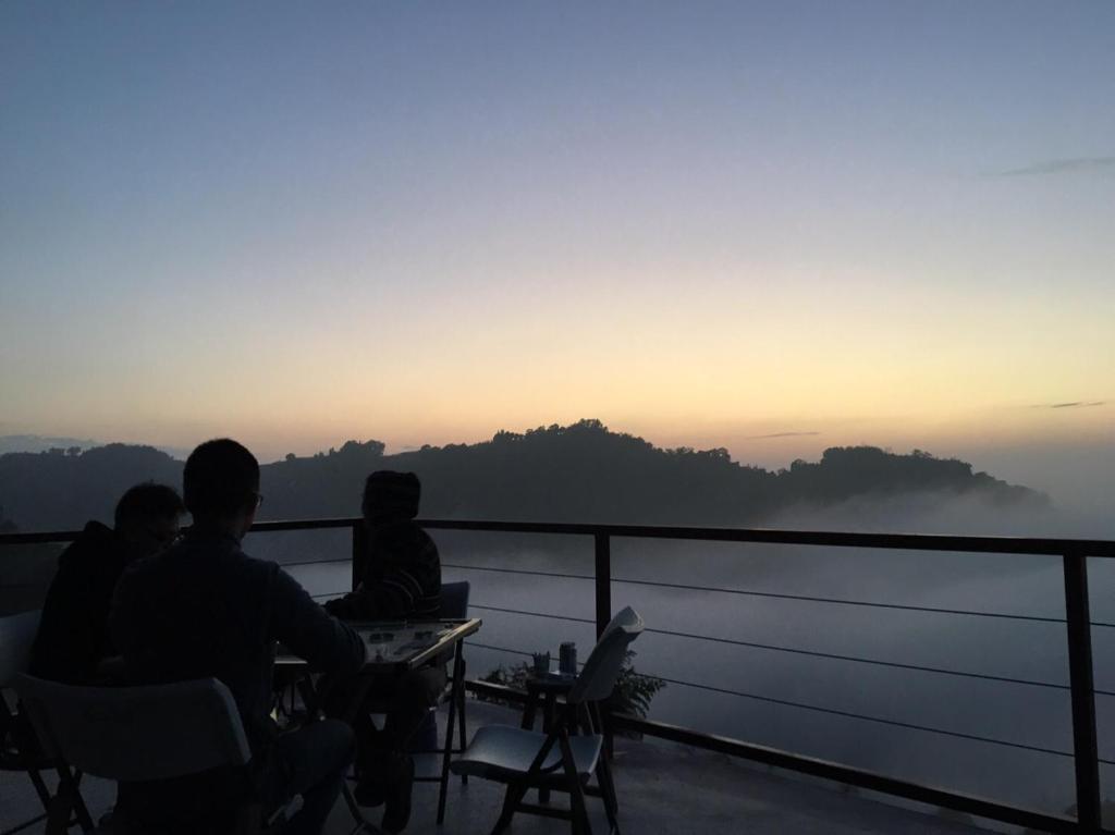 Dongshi歐森View包棟Villa x 雲海夜景 x 獨立空間的一群坐在桌子旁观看日落的人