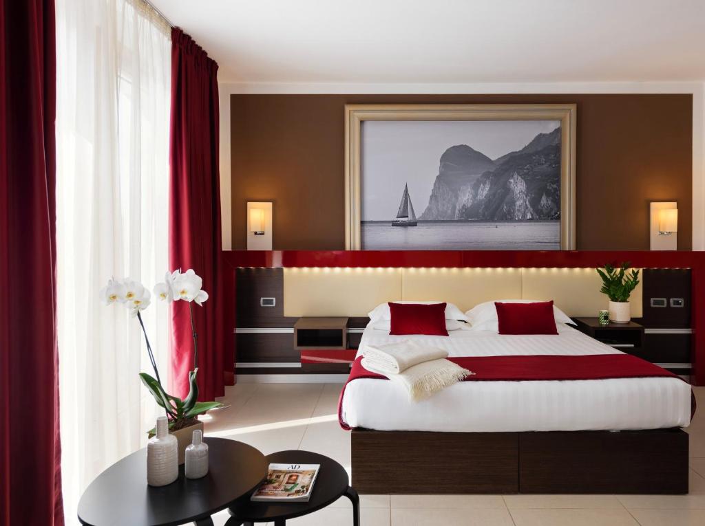卡斯特努沃德加尔达凯若斯加尔达酒店的一间卧室配有一张带红色窗帘的大床