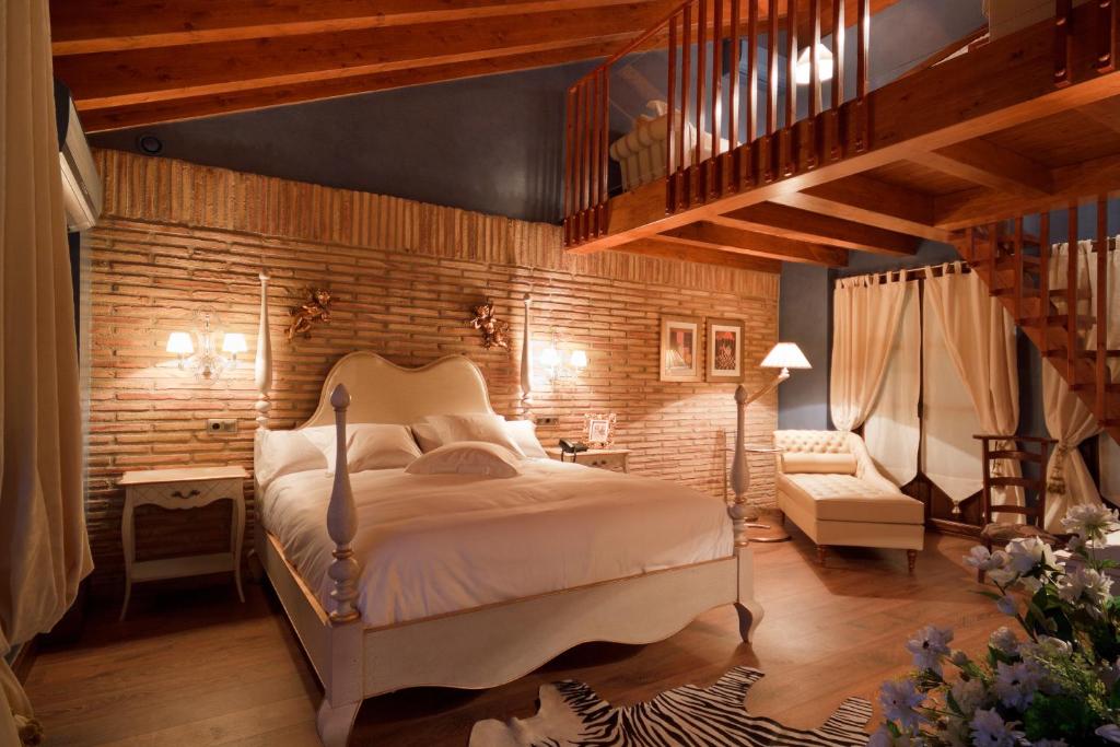 拉瓜迪亚洛斯帕拉赫斯酒店的一间卧室设有一张床和砖墙