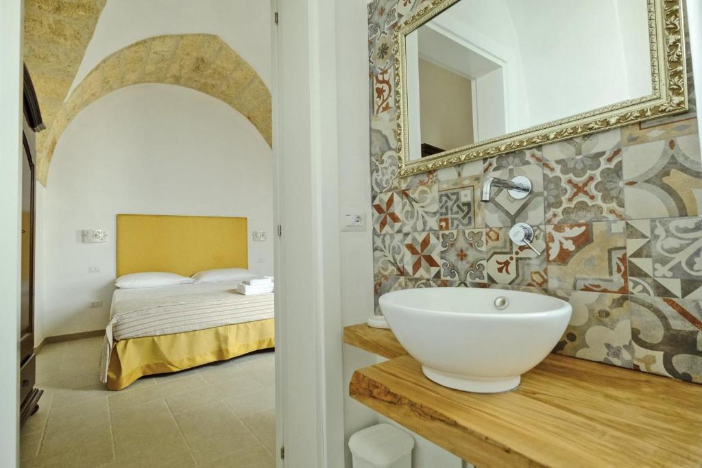 乌真托Corte Scarcia的一间带水槽的浴室和一张带镜子的床