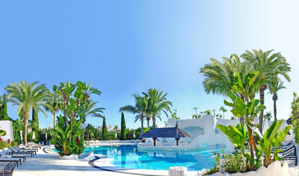 阿尔姆尼卡阿尔拜辛德尔马套房酒店的一个带游泳池和棕榈树的度假村