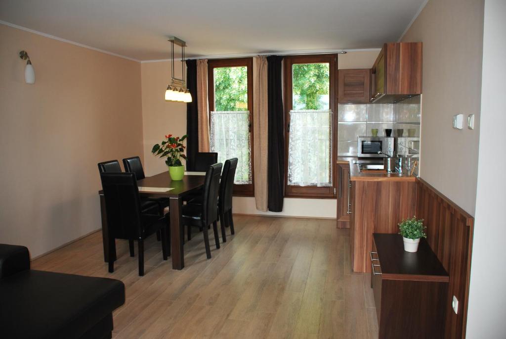 久洛Albatrosz Apartman的用餐室以及带桌椅的厨房。