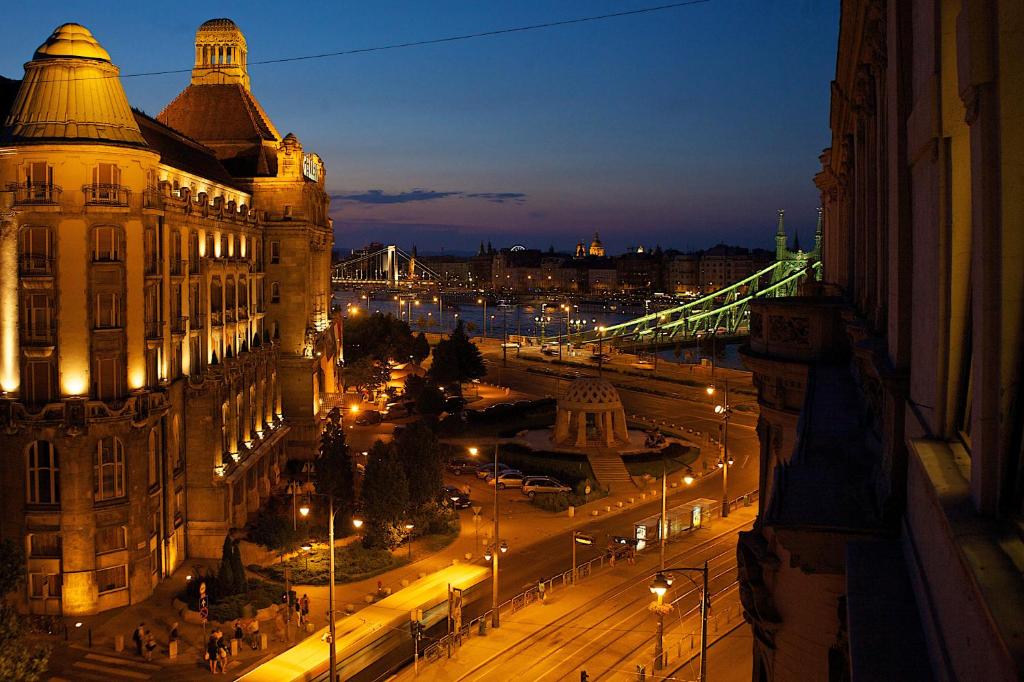 布达佩斯五季公寓酒店的享有城市的夜间美景,设有一座桥