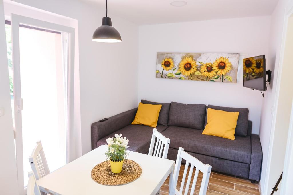 伊佐拉Adel apartment的客厅配有沙发和带黄色枕头的桌子。