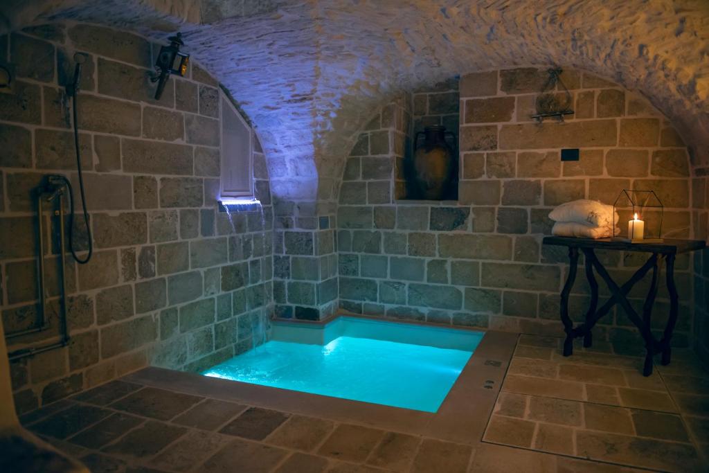 马丁纳弗兰卡Relais l’Antico Pozzo的一间带浴缸的浴室,位于石墙内