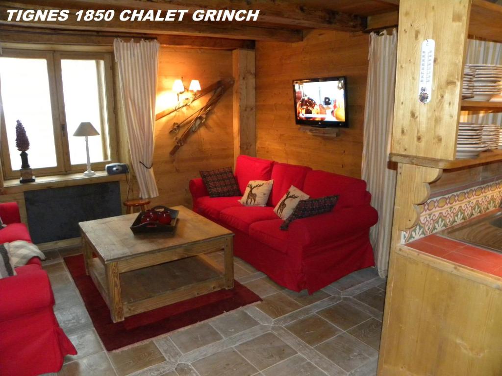 蒂涅CHALET GRINCH 90m2, 3 Sdb, skis aux pieds, wifi的客厅设有红色的沙发和壁炉