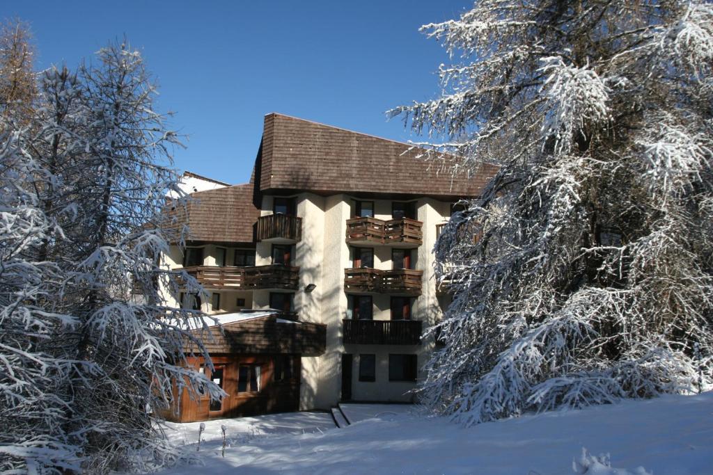 莱索尔莱斯特拉帕斯酒店的雪地中的一座建筑,有雪覆盖的树木