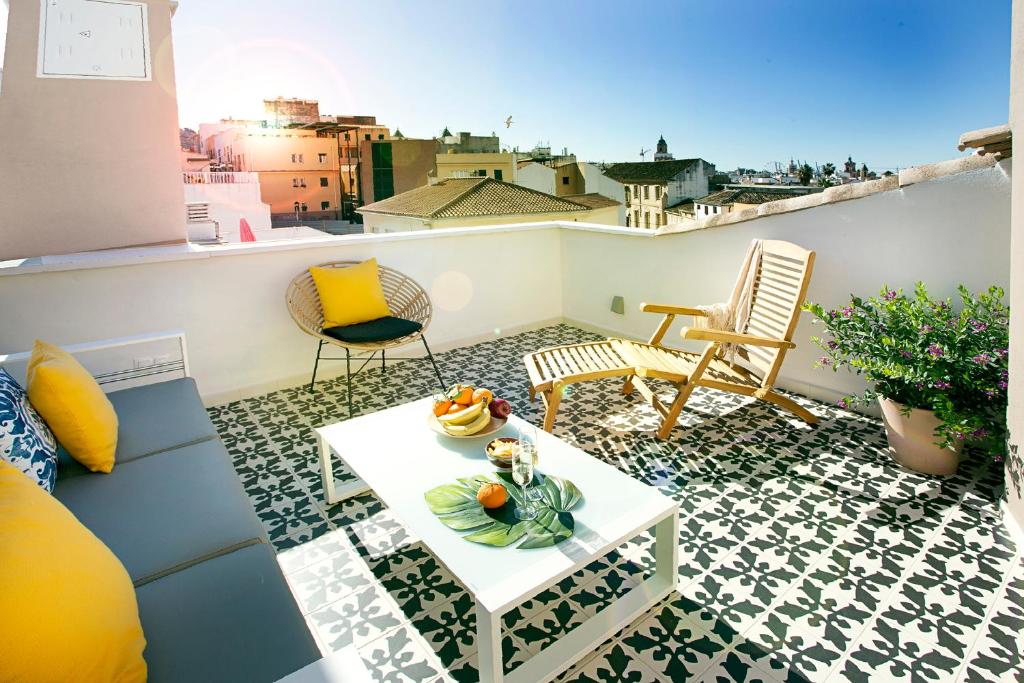 马拉加Graffiti Suites Málaga的屋顶上带桌椅的小阳台