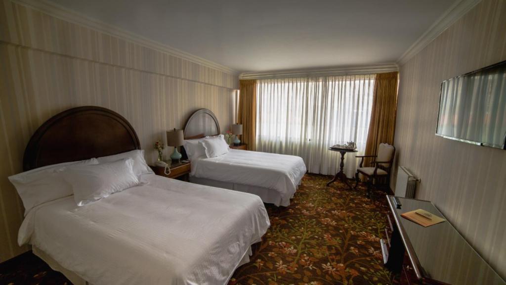 波托西克罗索波托西酒店的酒店客房设有两张床和窗户。