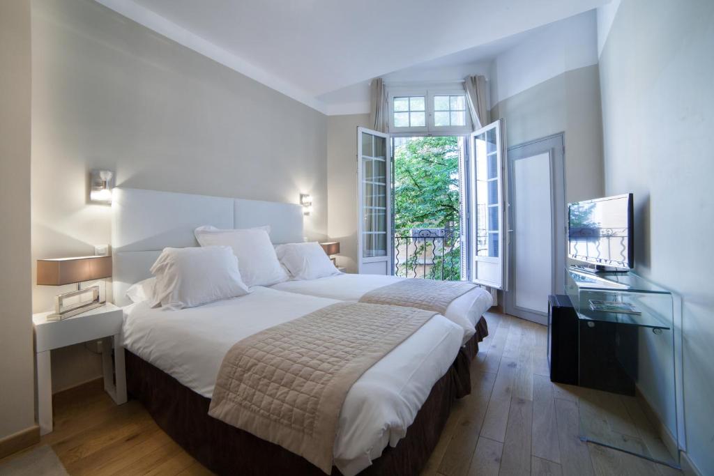普罗旺斯艾克斯法国酒店的一间卧室配有一张大床和电视