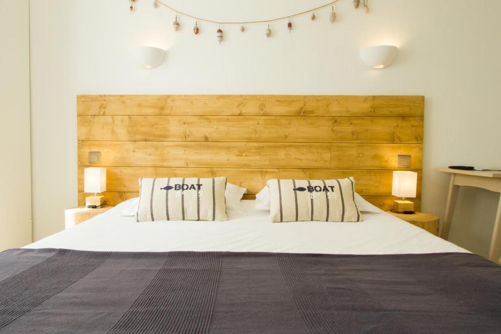 勒宝利古恩Casa Cosy Le Pouliguen的卧室配有一张带两个枕头的大白色床
