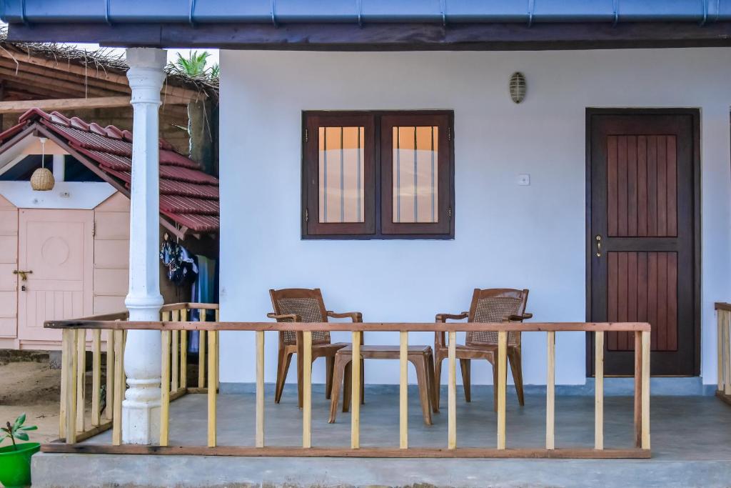 高尔Saman Beach Guest House的门廊上的木桌和椅子