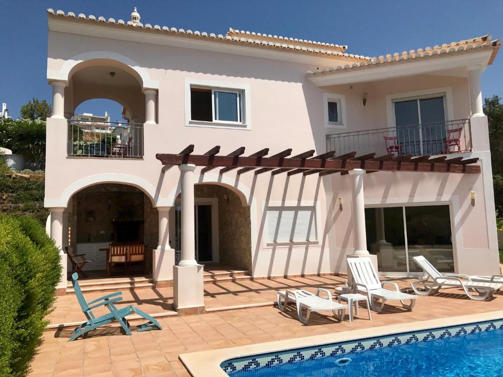 布德恩斯Lovely Burgau villa just 3 mins walk from beach的一座带游泳池和房子的别墅