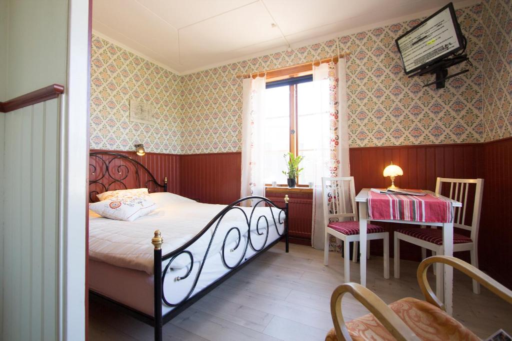 莫拉Prinsgården B&B rum stugor的一间卧室配有一张床、一张桌子和一个窗户。