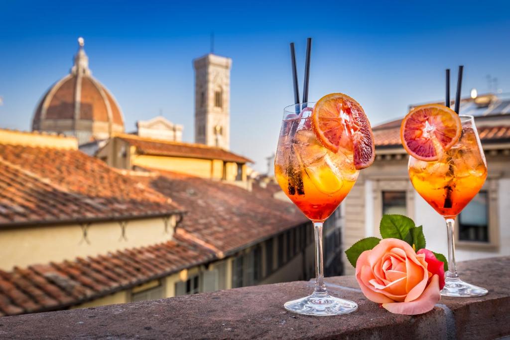 佛罗伦萨Palazzo dei Conti Residenza d'Epoca的三杯酒,坐在一顶酒柜上