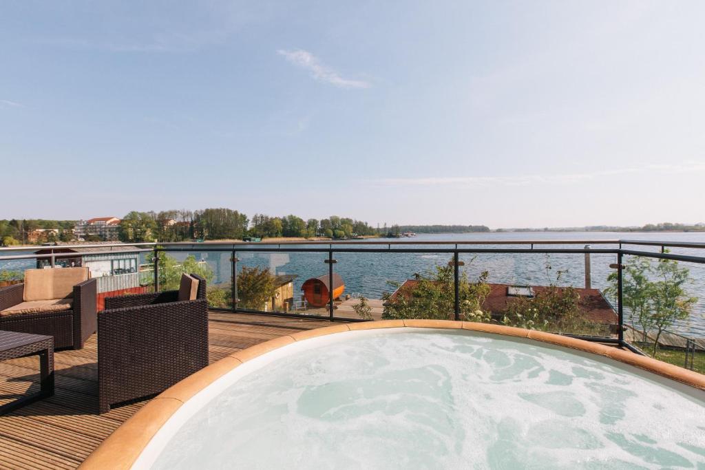 马尔肖因塞尔霍夫酒店的享有水景的甲板上的热水浴池