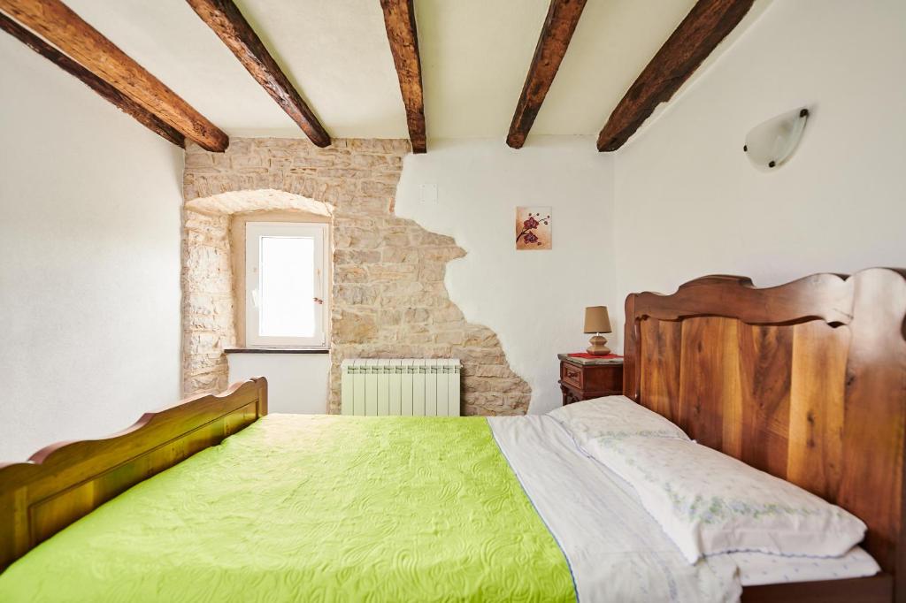 格罗日年App Lidia的一间卧室设有绿色的床和砖墙