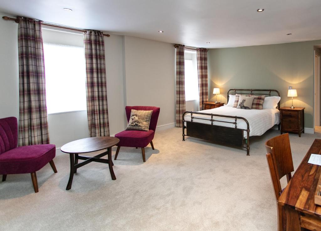 CongresburyThe Congresbury Arms的卧室配有一张床和一张桌子及椅子