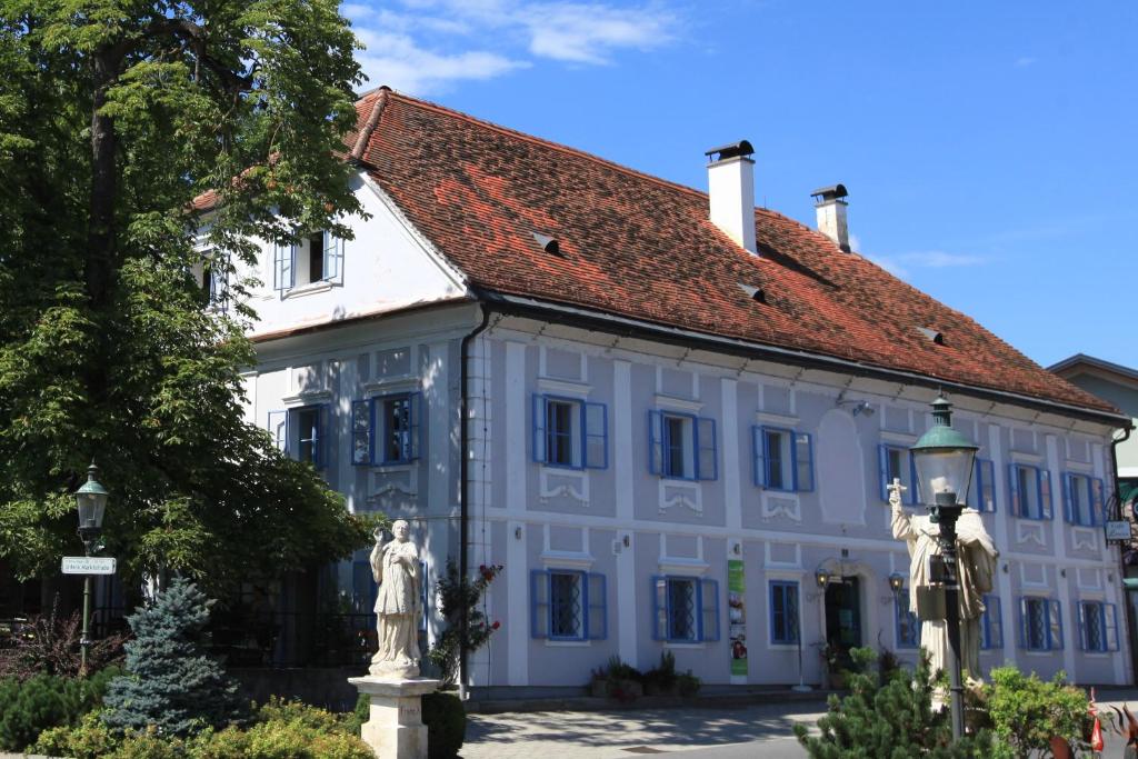 Sankt Veit am VogauDas Gästehaus的一座白色的大建筑,有红色的屋顶
