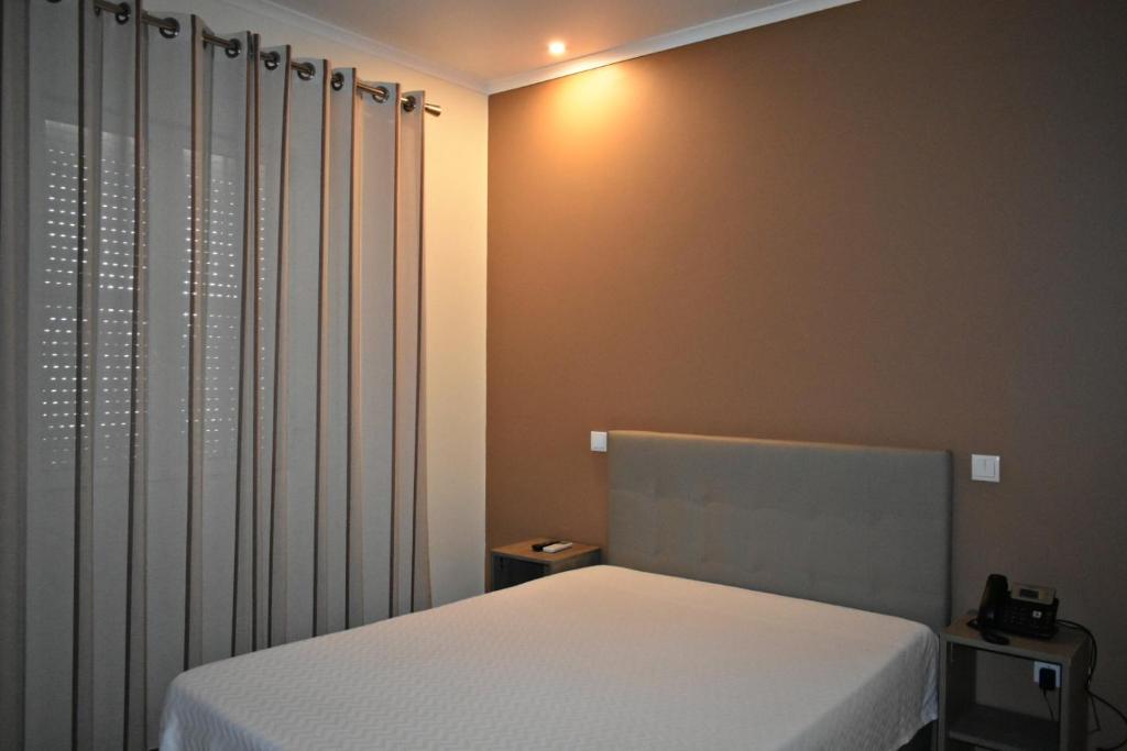 布朗库堡Horta D'Alva的卧室配有白色的床和窗帘
