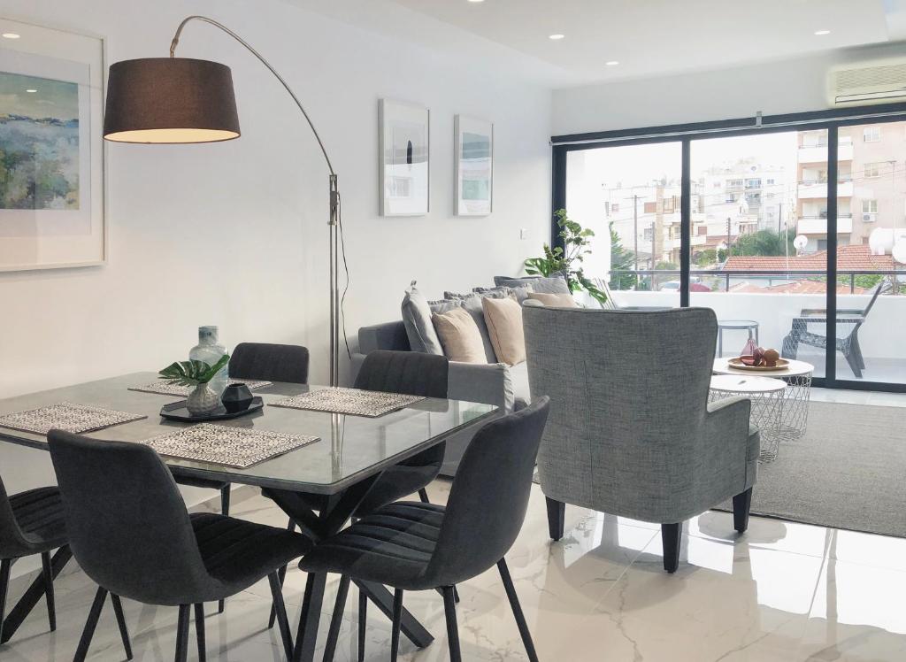 利马索尔Metro Court Apartments的一间设有玻璃桌和椅子的用餐室