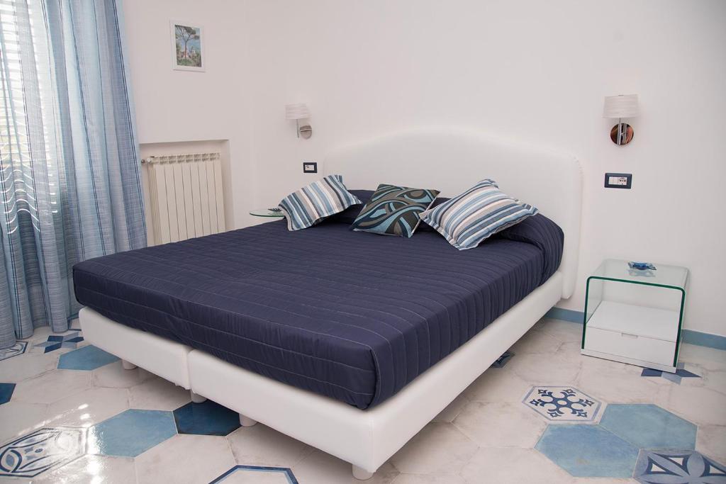 拉维罗La Gemma di Ravello的一间卧室配有一张大床,提供蓝色的床单和枕头