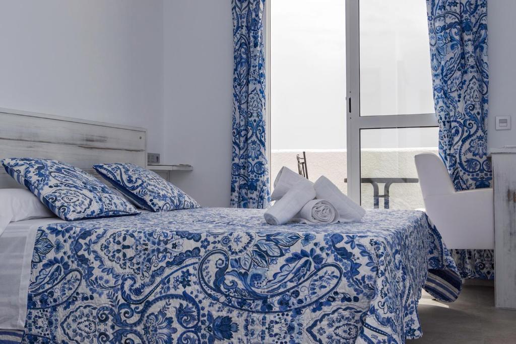 阿瓜阿马加La Palmera. El amanecer en el Parque Natural的卧室配有蓝色和白色的床和窗户。