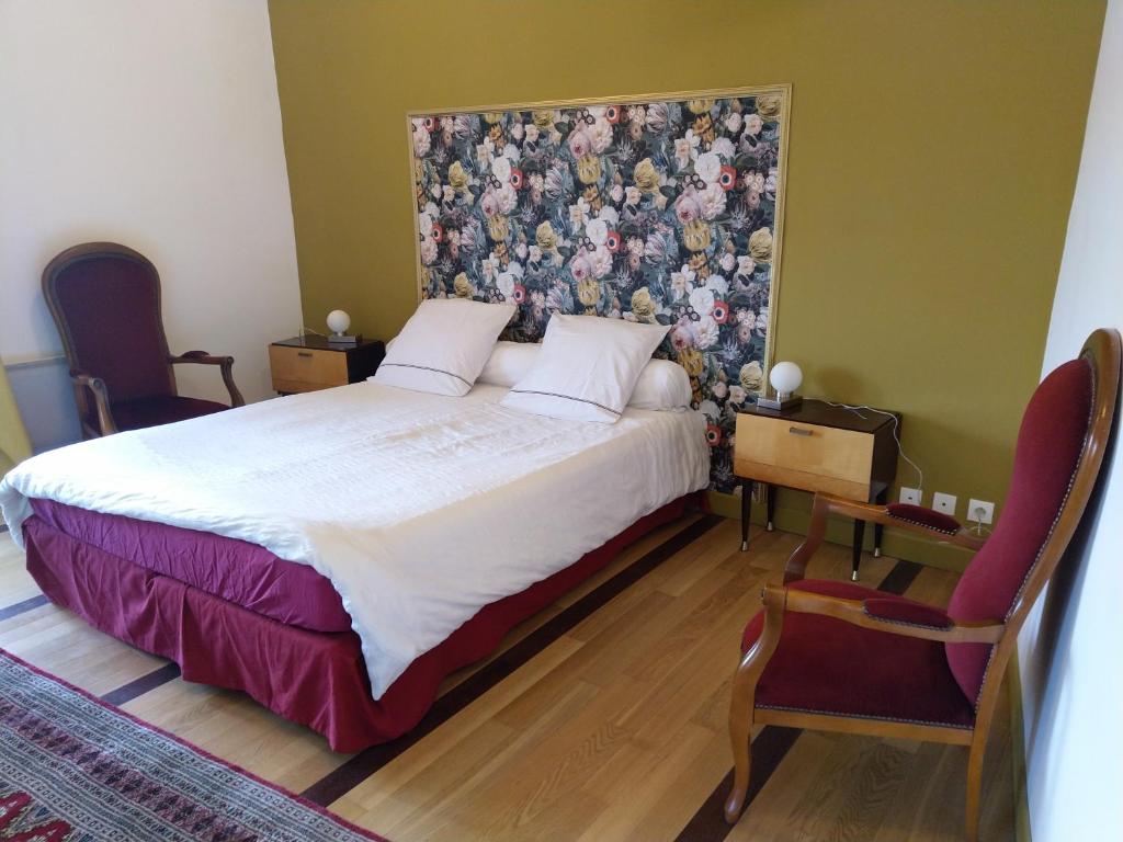 绍维尼Tour Duguesclin的一间卧室配有一张大床和花卉床头板