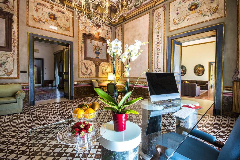 埃尔科拉诺VILLA DURANTE的客厅配有带笔记本电脑的玻璃桌