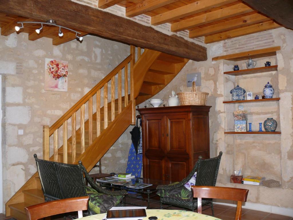 圣艾米隆Les Oiseaux的客厅设有木制楼梯和椅子