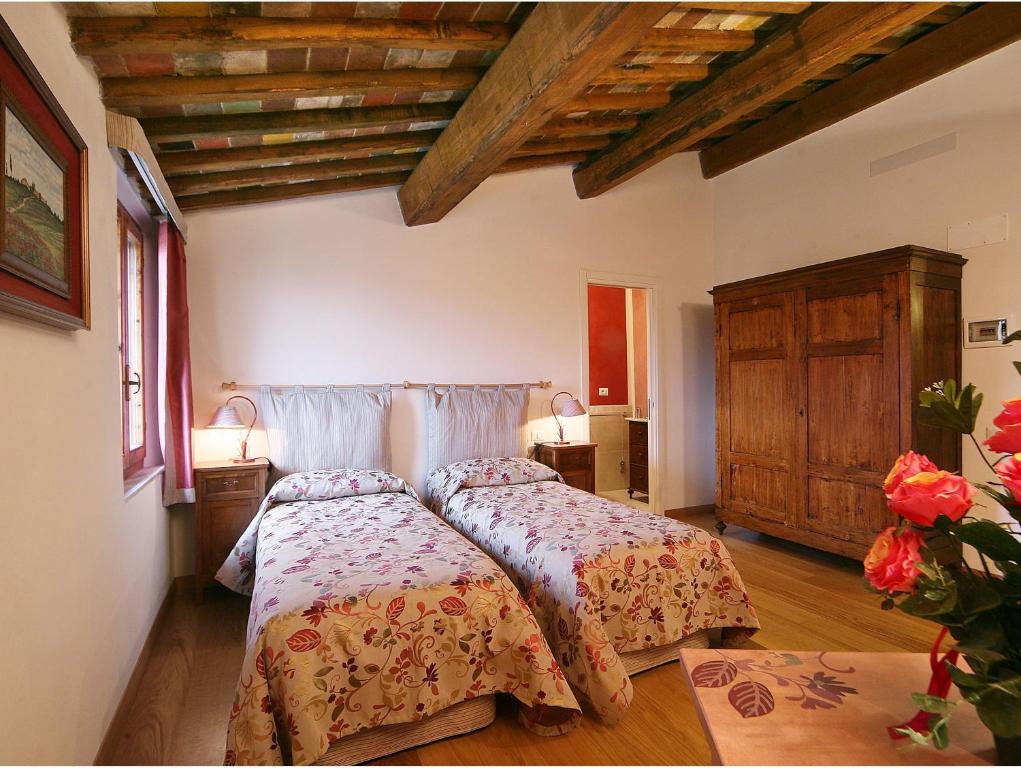 锡耶纳Casacenti B&B的一间卧室设有一张床和木制天花板