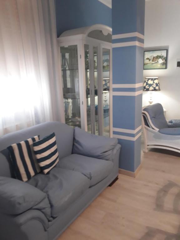 切萨雷奥港Loving Salento的客厅设有灰色的沙发和蓝色的墙壁。