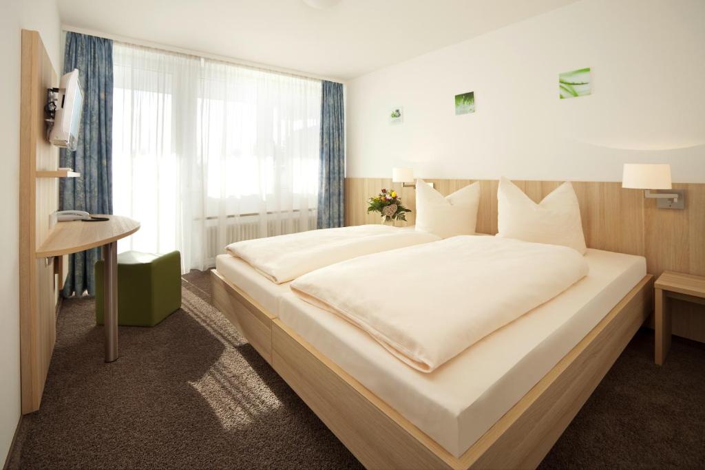弗赖辛勒纳旅馆的一张位于酒店客房的大床,设有窗户