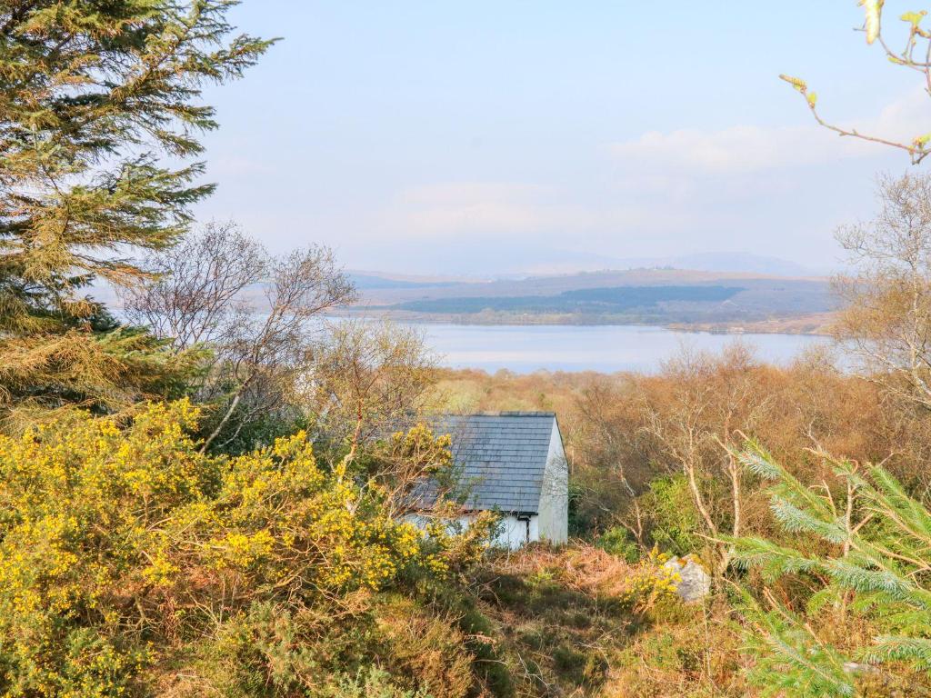 CarrigartLough View Cottage的一座位于山边的老房子,有湖泊