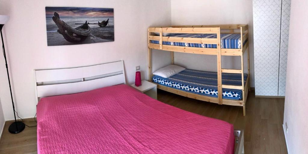 玛格丽塔萨沃亚Rose Beach Apartment的一间卧室配有两张双层床和粉红色的毯子