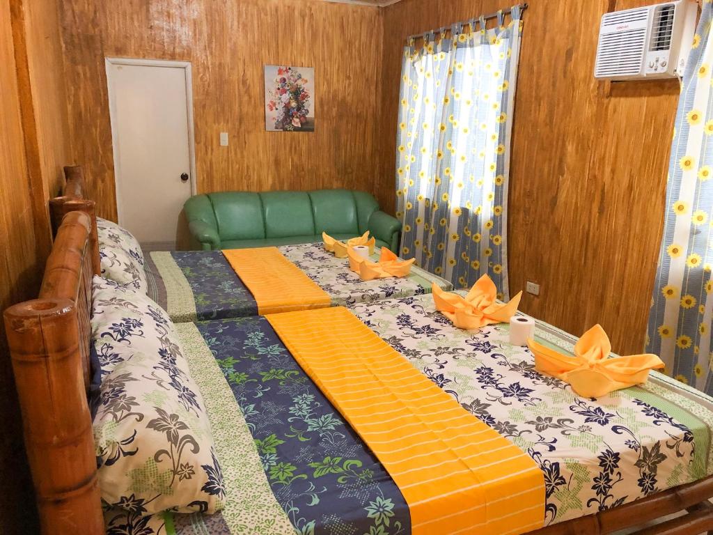 邦劳Ging Ging Homes Alona Beach的一间卧室,配有一张带橙色弓的床