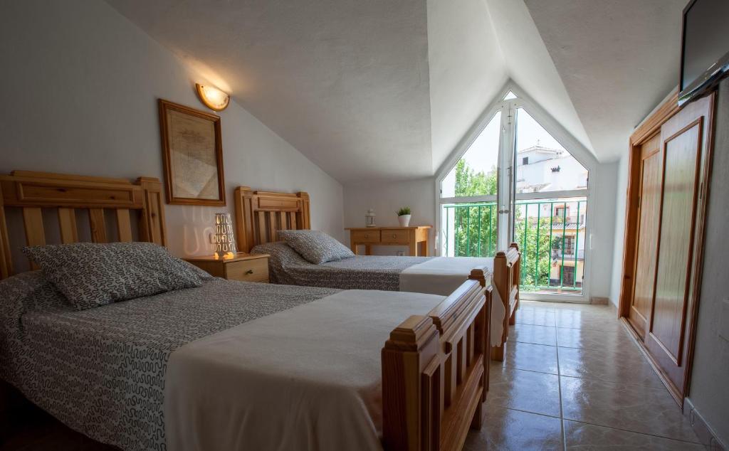 Alozaina桑戈塞拉德拉斯涅韦斯旅舍的一间卧室设有两张床和大窗户