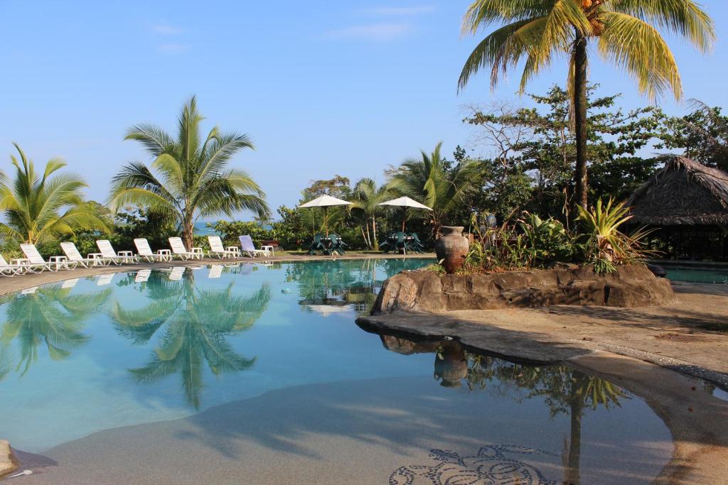 Buena Vista波帕天堂海滩度假村 的一个带椅子的游泳池,棕榈树