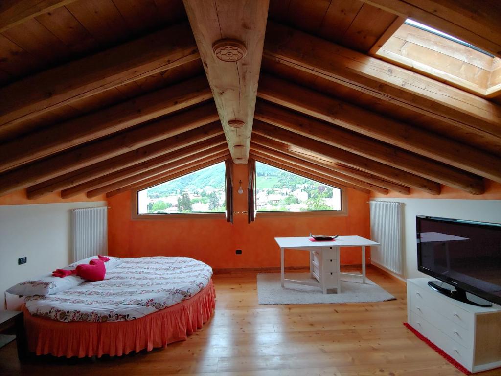 瓦尔多比亚德内Casa Dolce Casa的一间卧室设有橙色的墙壁和一张带电视的床。